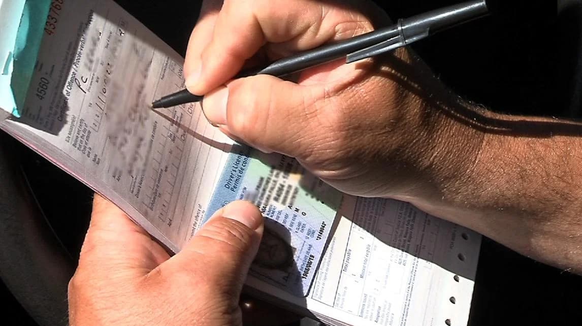 Une main remplit un formulaire papier.