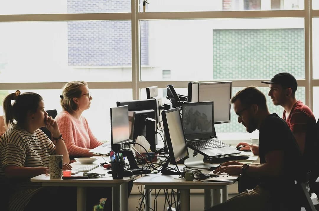 Colleagues working at computers in a shared office.