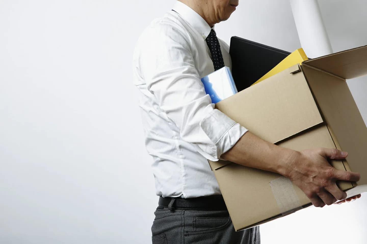 A person carrying cardboard boxes and folders.