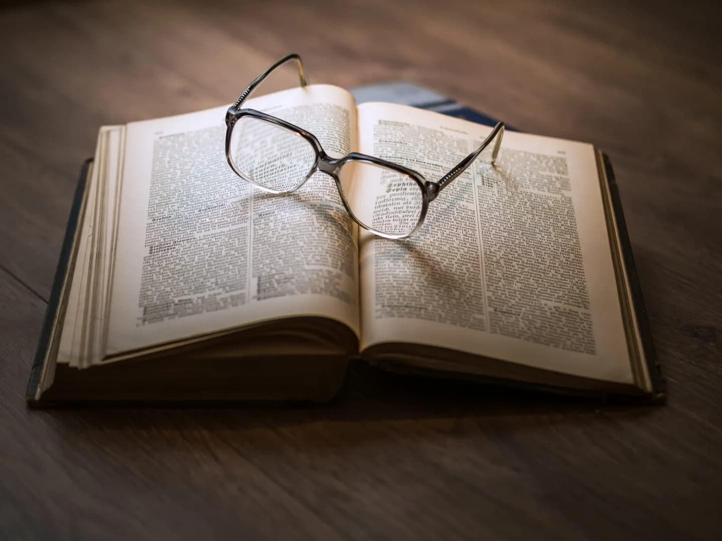 Reading glasses resting on an open book.