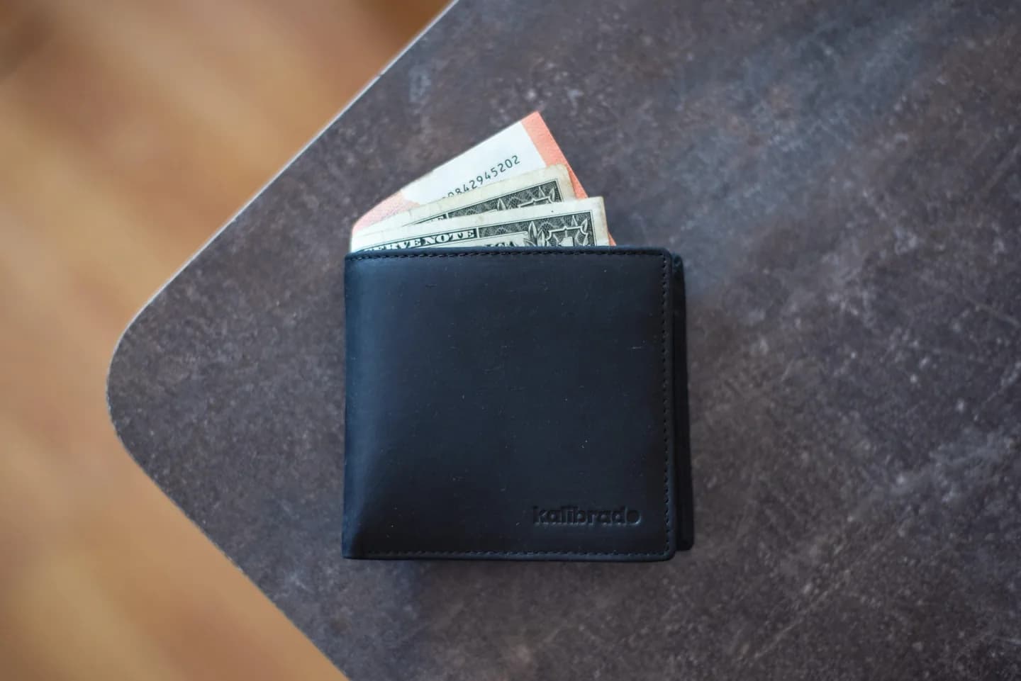A wallet with banknotes on a tabletop.