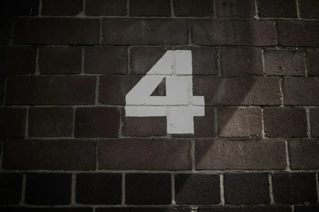 The number four painted on a brick wall.